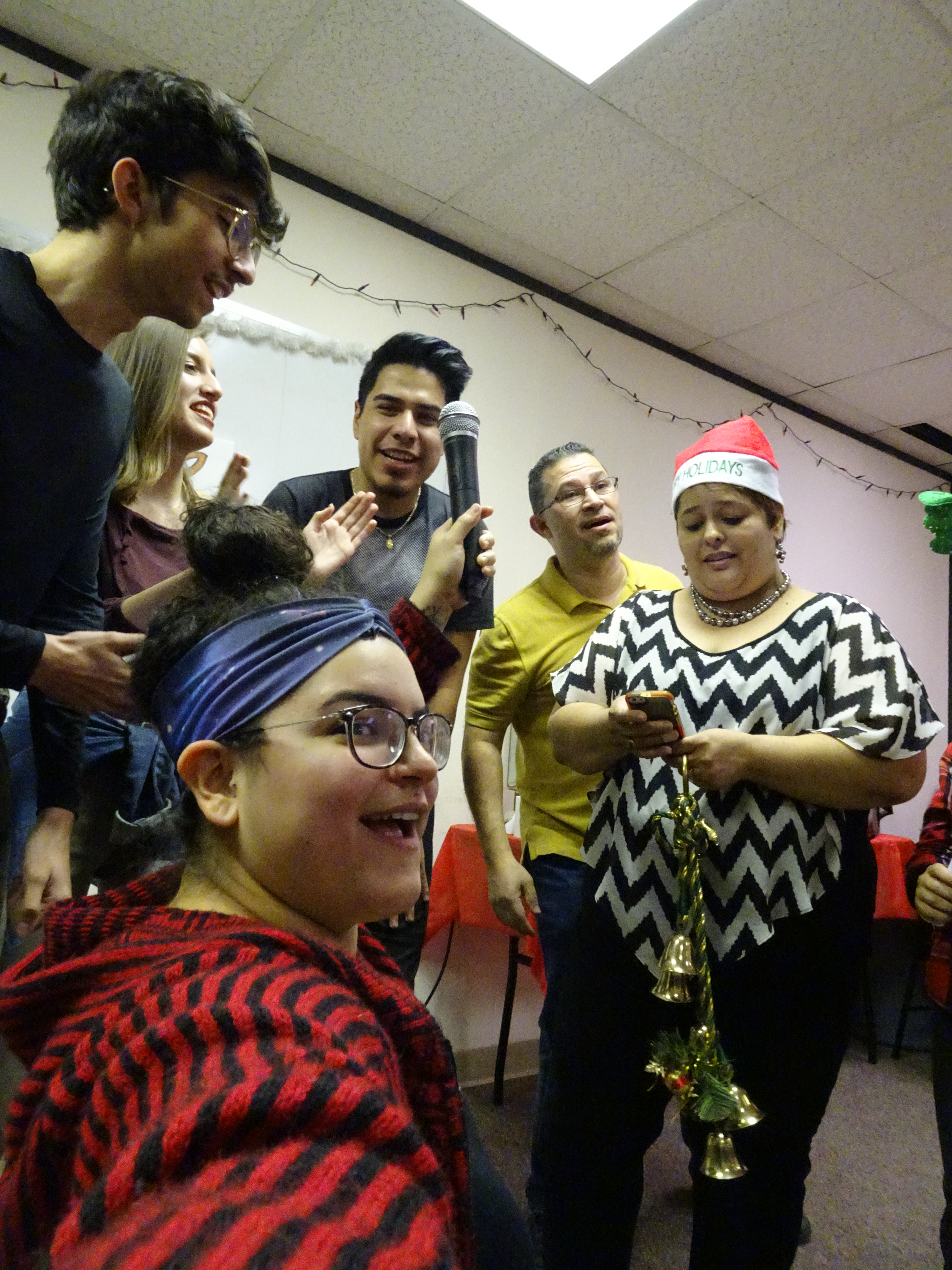Group of friends at El Pueblo singing Christmas carols during our holiday potluck. Un grupo de amigos cantando durante nuestra fiesta.